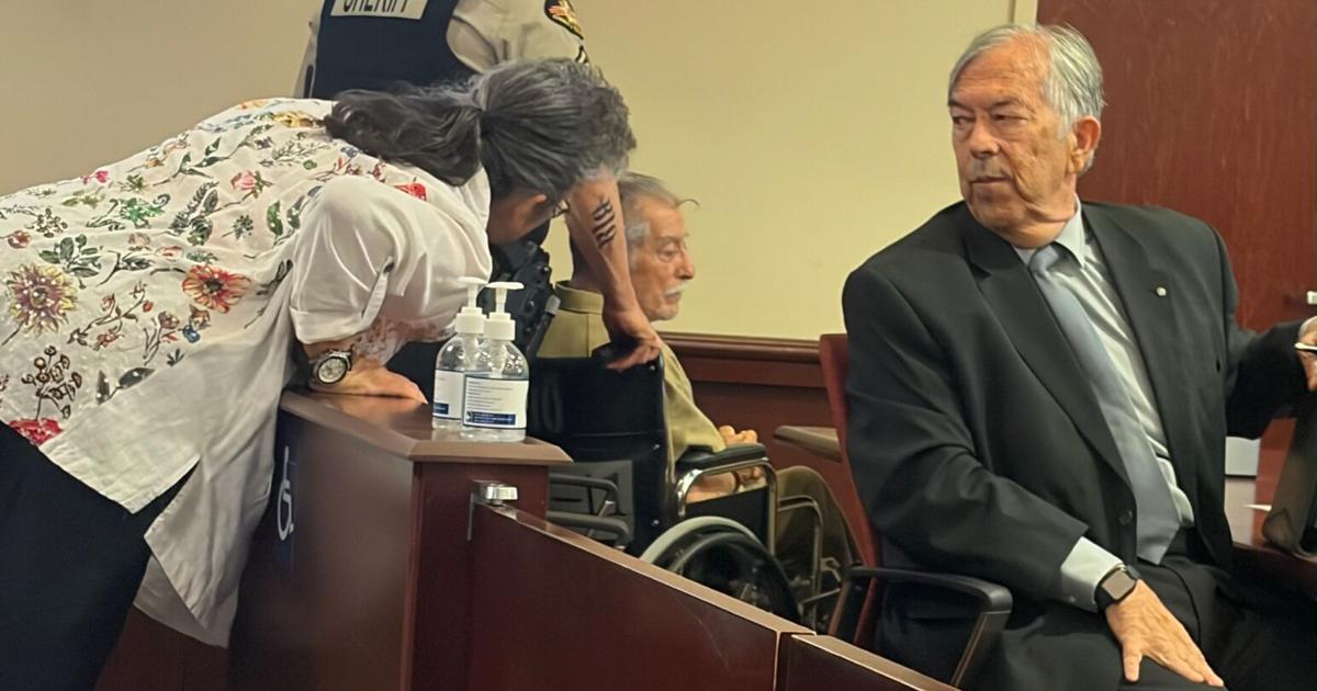 Marsha Chavez speaks to Ben Noverto Martinez during a hearing as Stephen Aarons looks on.